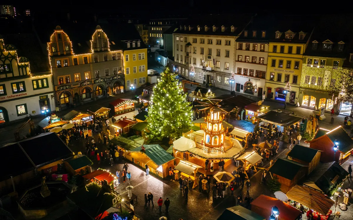 Weihnachtsmarkt in Weimar mit festlich beleuchteten Ständen und großem Weihnachtsbaum.