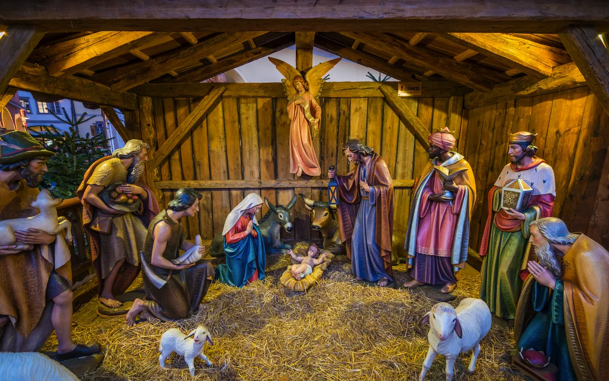 Weihnachtskrippe mit Holzfiguren, Maria, Josef und Christkind in der Mitte.