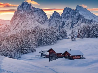 Verschneite Hütte in Berglandschaft bei Sonnenaufgang