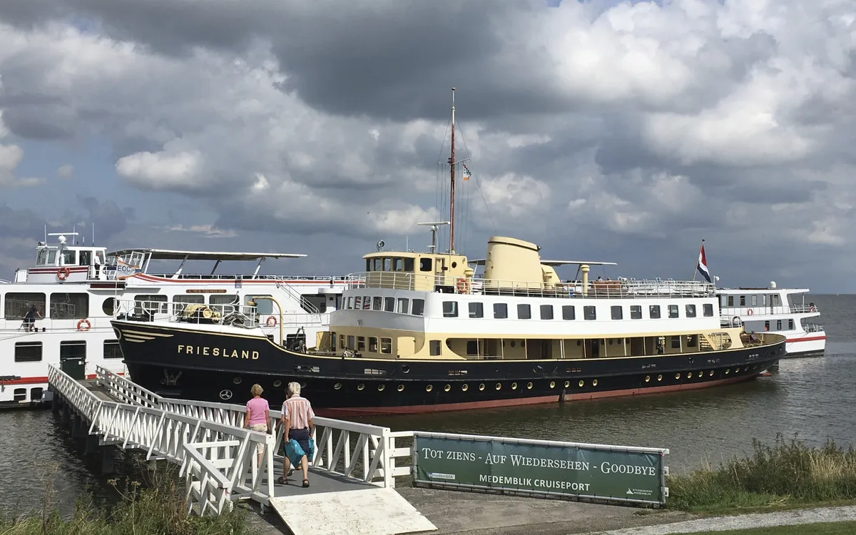 Museumsschiff Friesland am Pier bei bewölktem Himmel.
