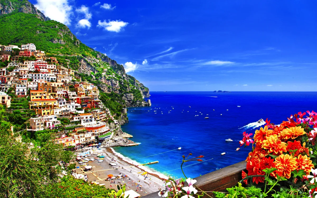 Positano an der Amalfiküste mit Steilhängen und blauem Meer im Hintergrund.