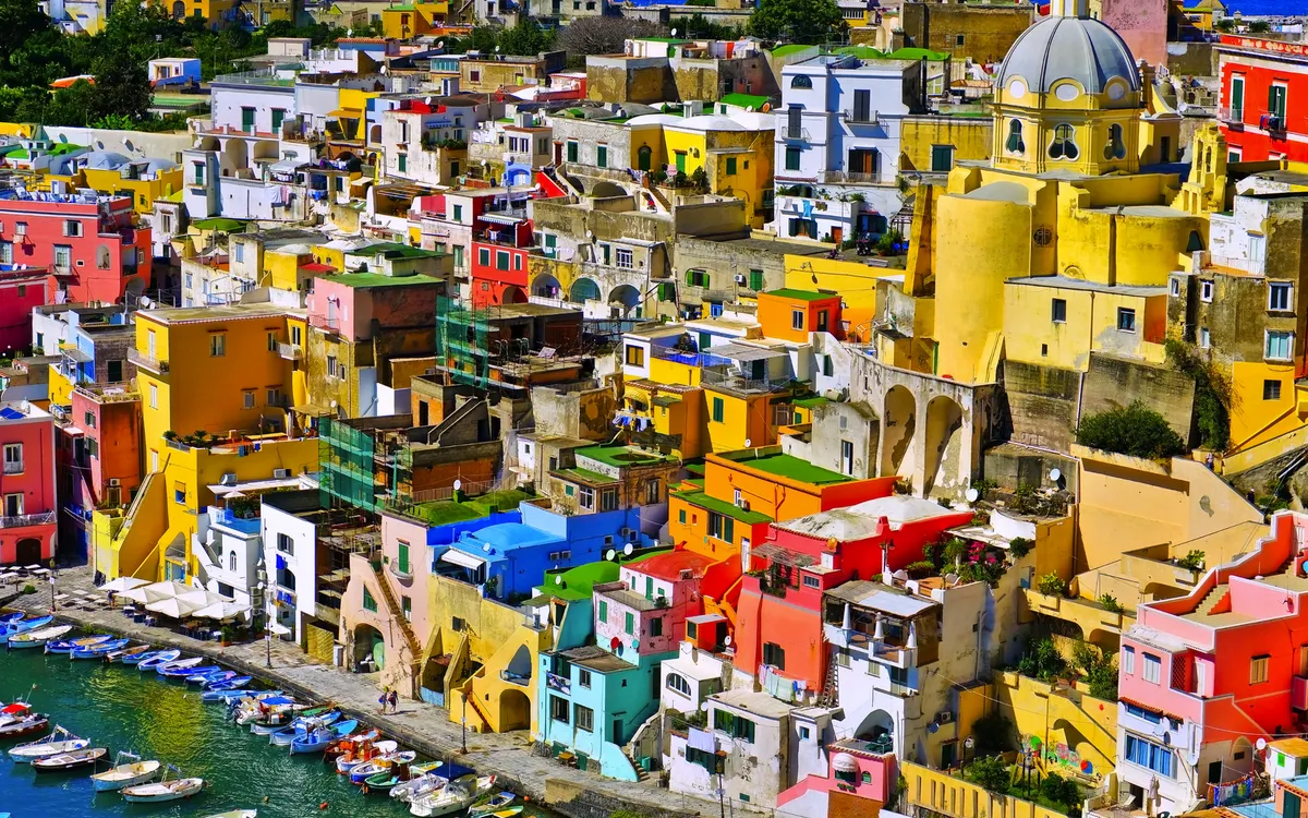 Bunter Hafen mit Booten und farbenfrohen Häusern auf der Insel Procida, Italien.
