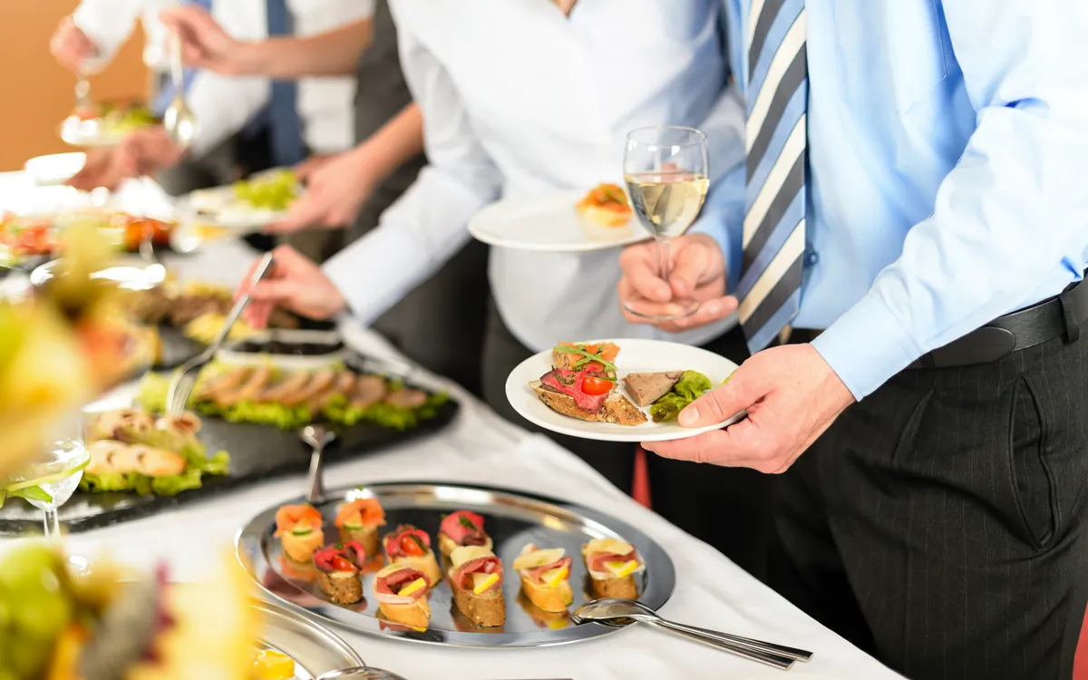 Geschäftsleute nehmen Vorspeisen vom Buffet