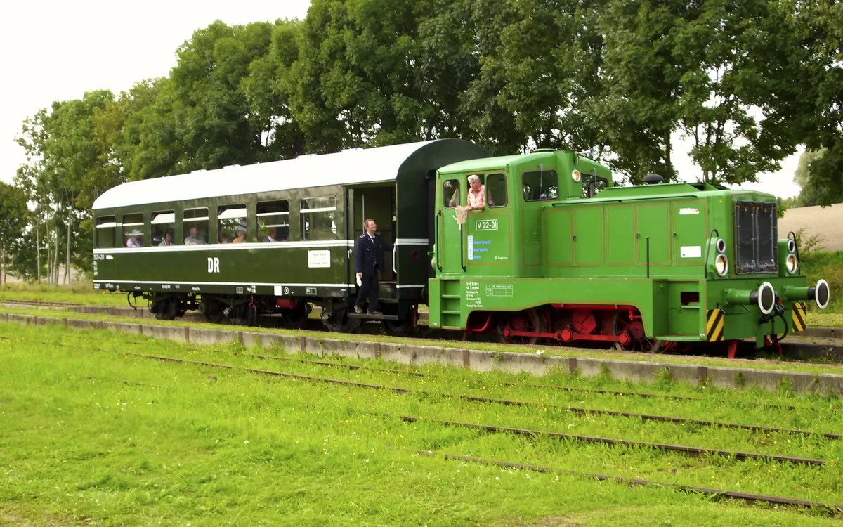 Grüne Museumsbahn mit Personenwaggon auf einem Gleis in Gramzow.