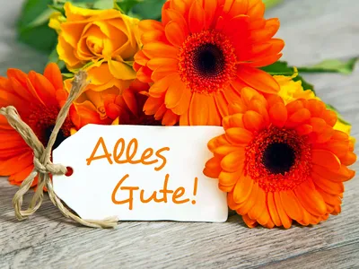 Blumenstrauß mit Rosen und Gerbera, Schild mit "Alles Gute" beschriftet.