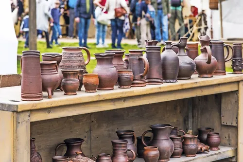 Töpferwaren auf Holztisch am Töpfermarkt im Freien ausgestellt.