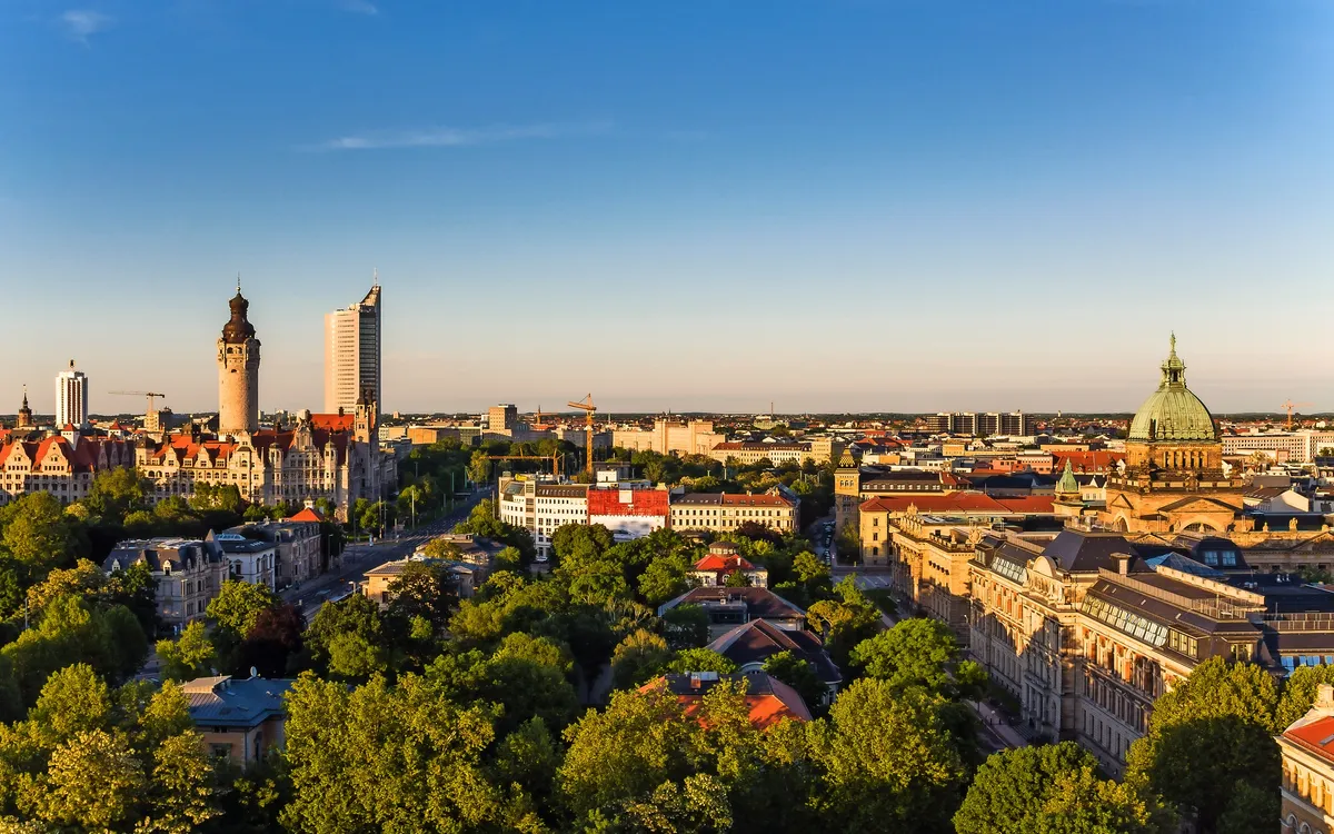 Panorama von Leipzig mit Rathaus und Thomaskirche im Sonnenlicht.