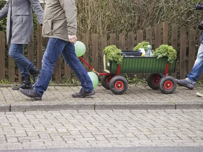 Personen ziehen einen Bollerwagen mit Grünkohl bei einer Winterwanderung.