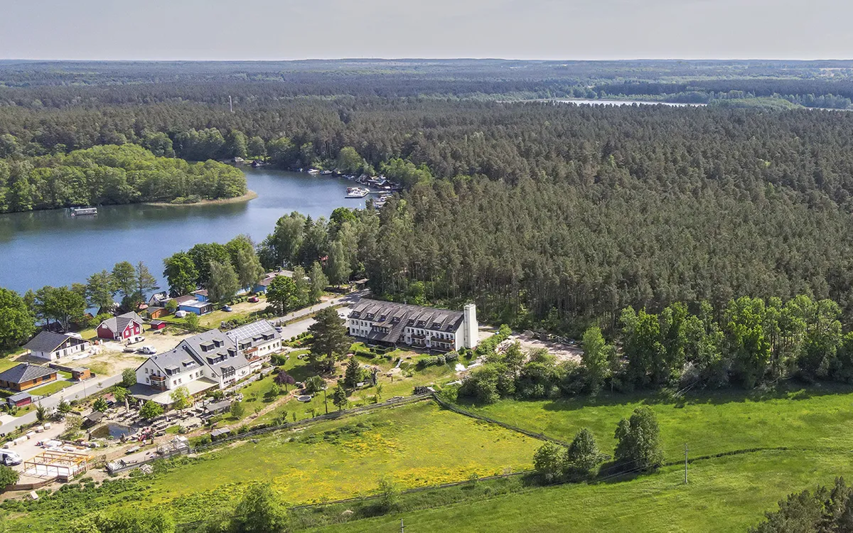 Luftaufnahme von Hotel Gutenmorgen und umliegender Wald- und Seenlandschaft.