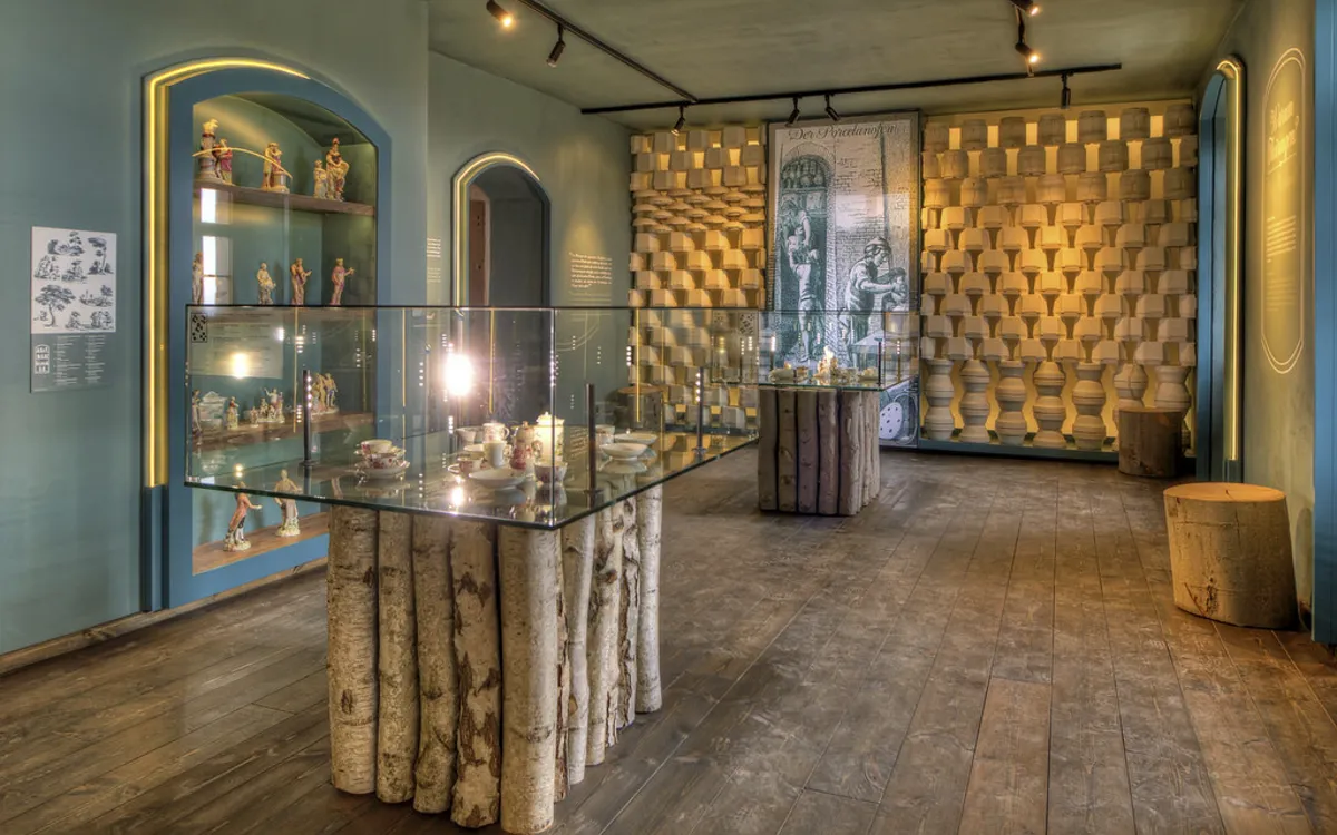 Ausstellungsraum in der Leuchtenburg mit Vitrinen und Wandkunst.