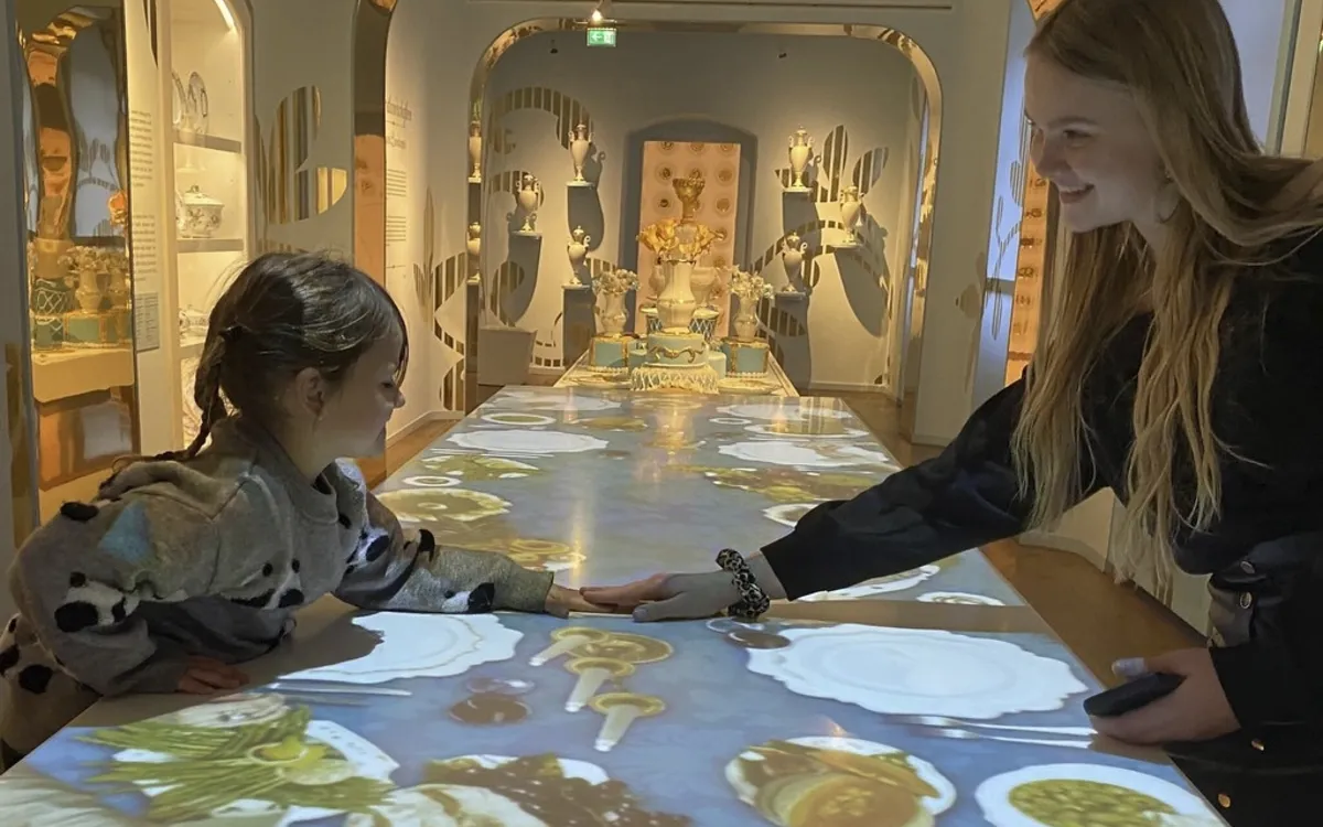 Zwei Personen betrachten eine digitale Projektion in einem Museum.