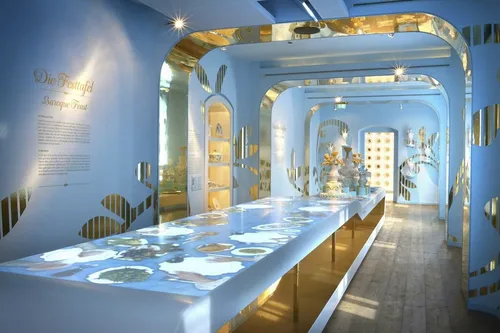Interaktive Ausstellung in einem modernen, blau-goldenen Raum auf der Leuchtenburg.