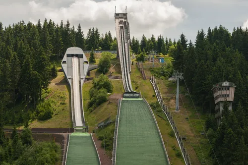 Sprungschanzen in einer bergigen Waldlandschaft mit dem Namen "Oberhof" auf einer der Anlauframpe.