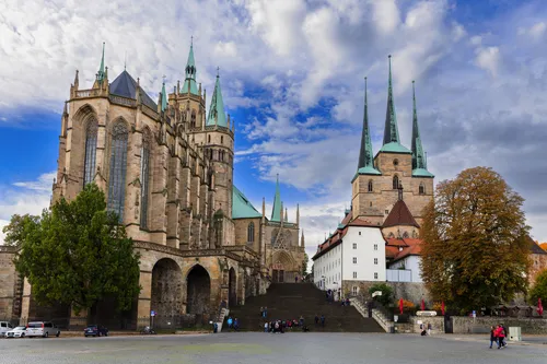 Historische Kirche mit hohen Türmen und blauem Himmel im Hintergrund.