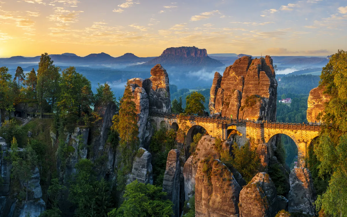 Felsformation mit Brücke in malerischer Landschaft bei Sonnenaufgang