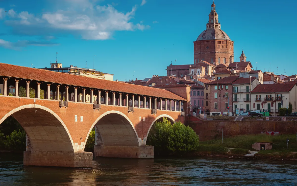 Brücke über einen Fluss mit historischer Architektur im Hintergrund.