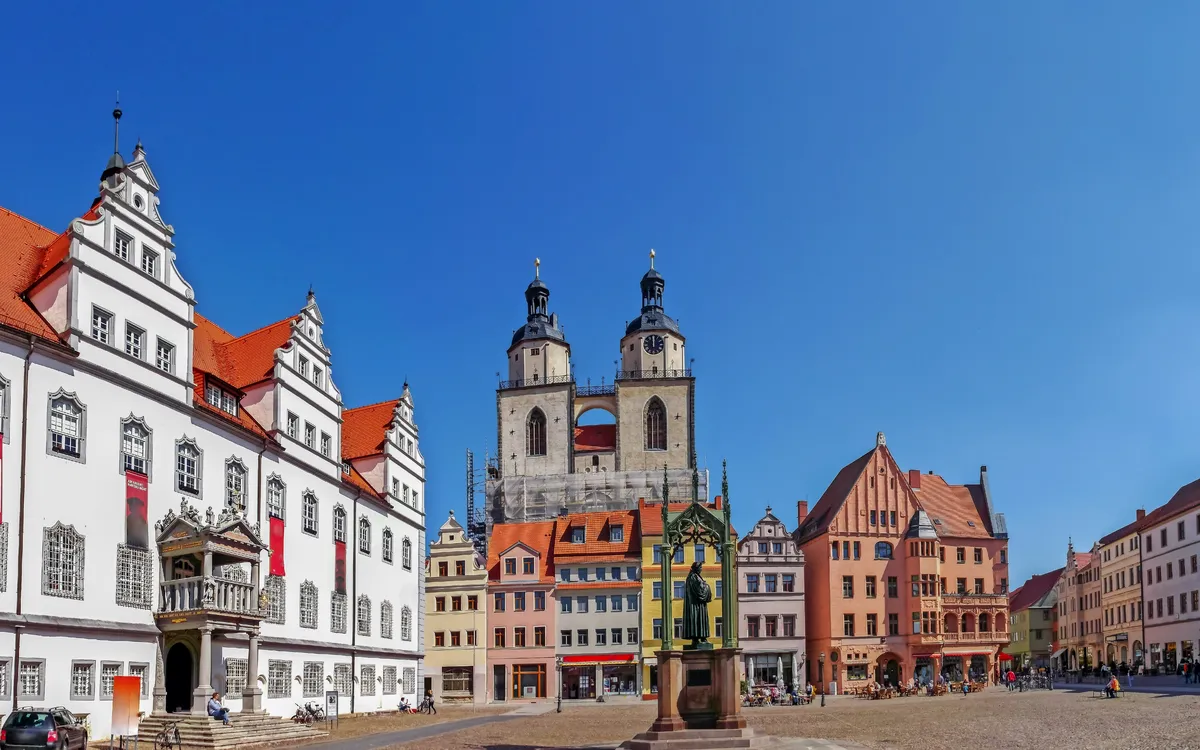 Historische Gebäude um einen Marktplatz bei klarem Himmel.