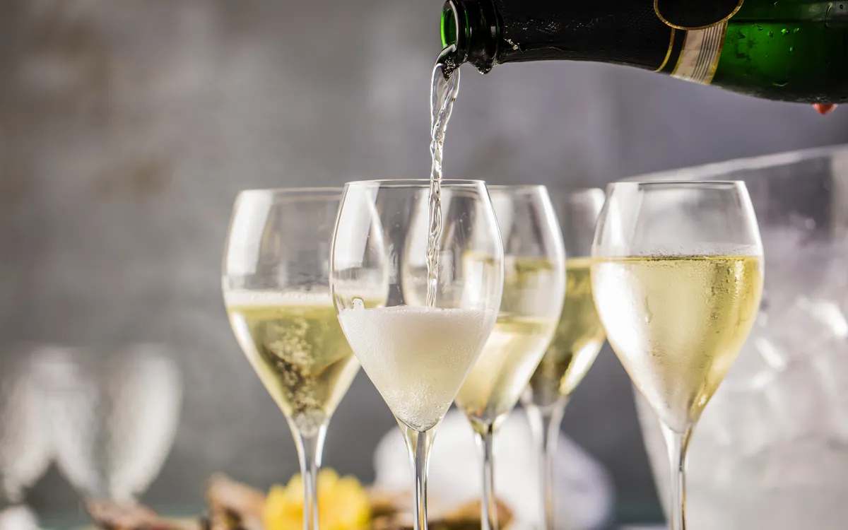 Champagner wird in Weingläser eingeschenkt.