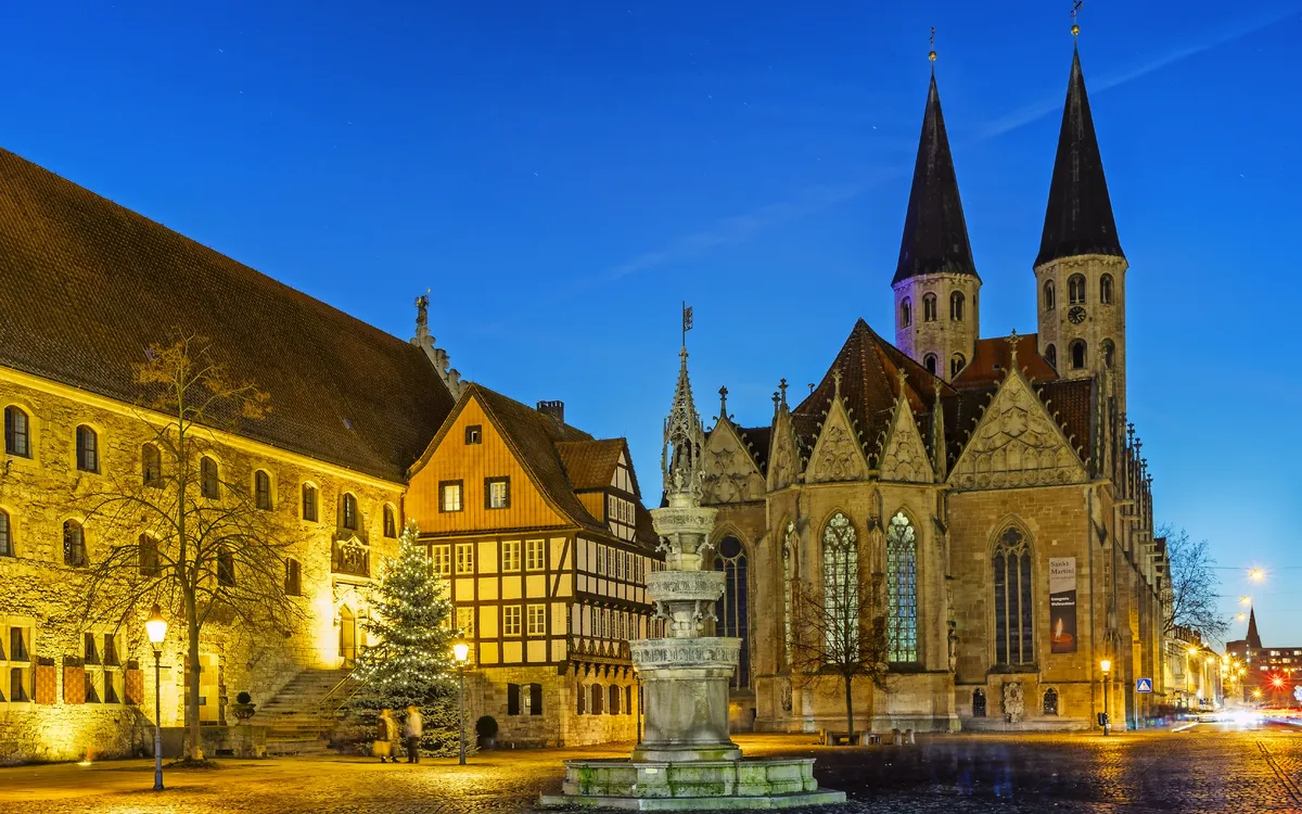 Historische Gebäude und Kirche bei Abenddämmerung, beleuchtet und malerisch.
