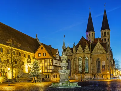 Historische Gebäude und Kirche bei Abenddämmerung, beleuchtet und malerisch.