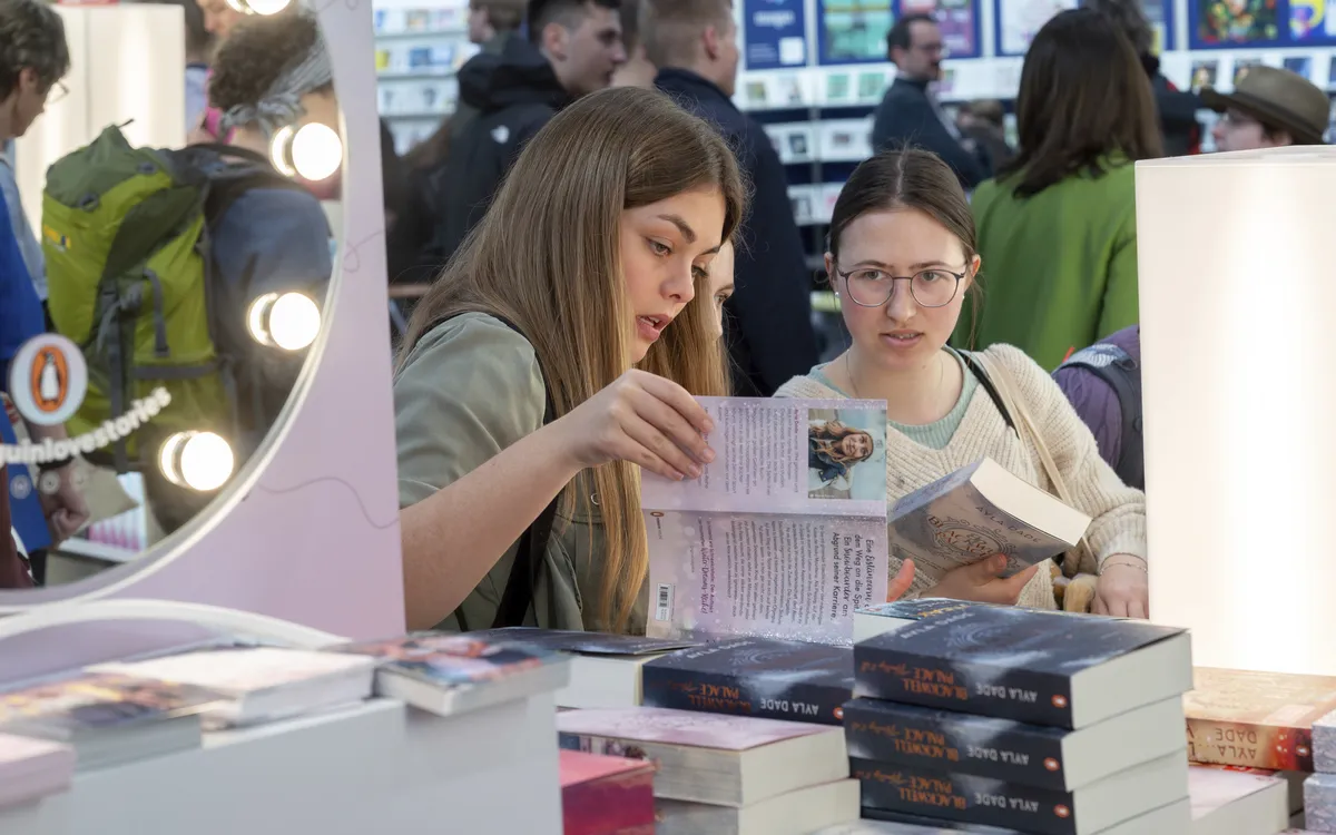 Zwei Frauen betrachten Bücher auf der Leipziger Buchmesse.