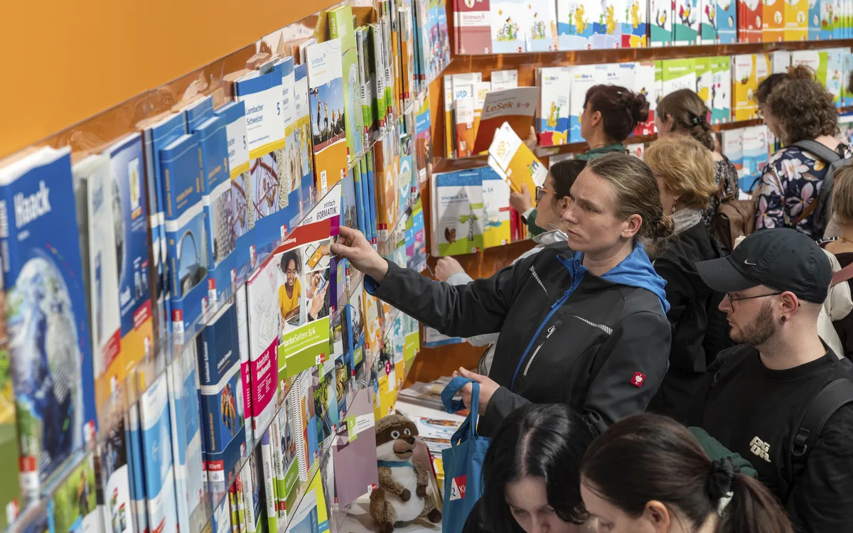 Personen betrachten Bücher an einem Stand auf der Leipziger Buchmesse.