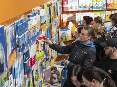 Personen betrachten Bücher an einem Stand auf der Leipziger Buchmesse.