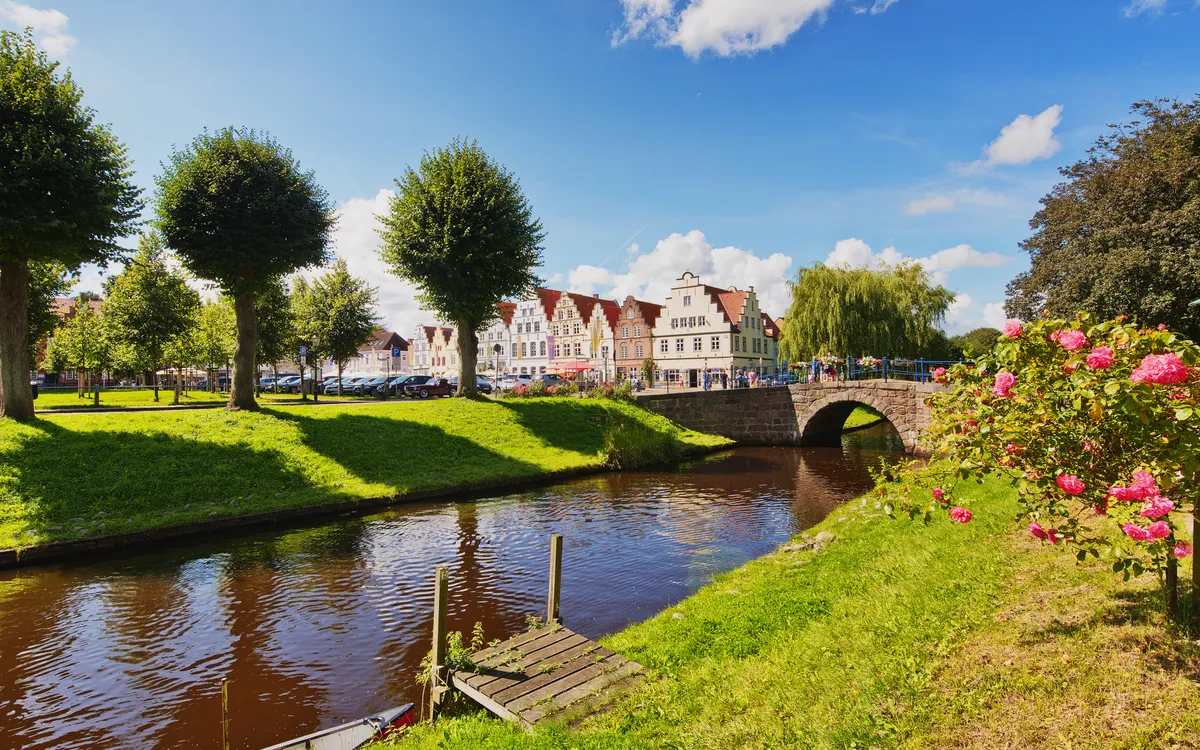 Kanalansicht im Luftkurort Friedrichstadt bei sonnigem Wetter mit historischen Häusern.