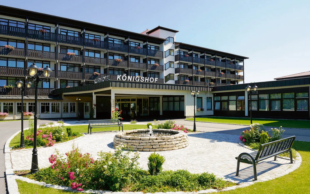 Außenansicht des Kurhotels Königshof mit Garten und Springbrunnen.