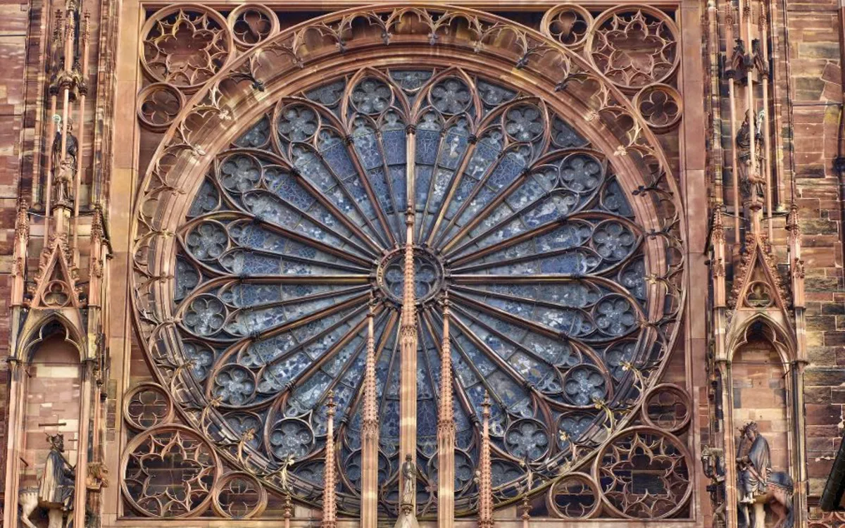 Rosettenfenster mit gotischen Steinmetzarbeiten an einer Kathedrale.