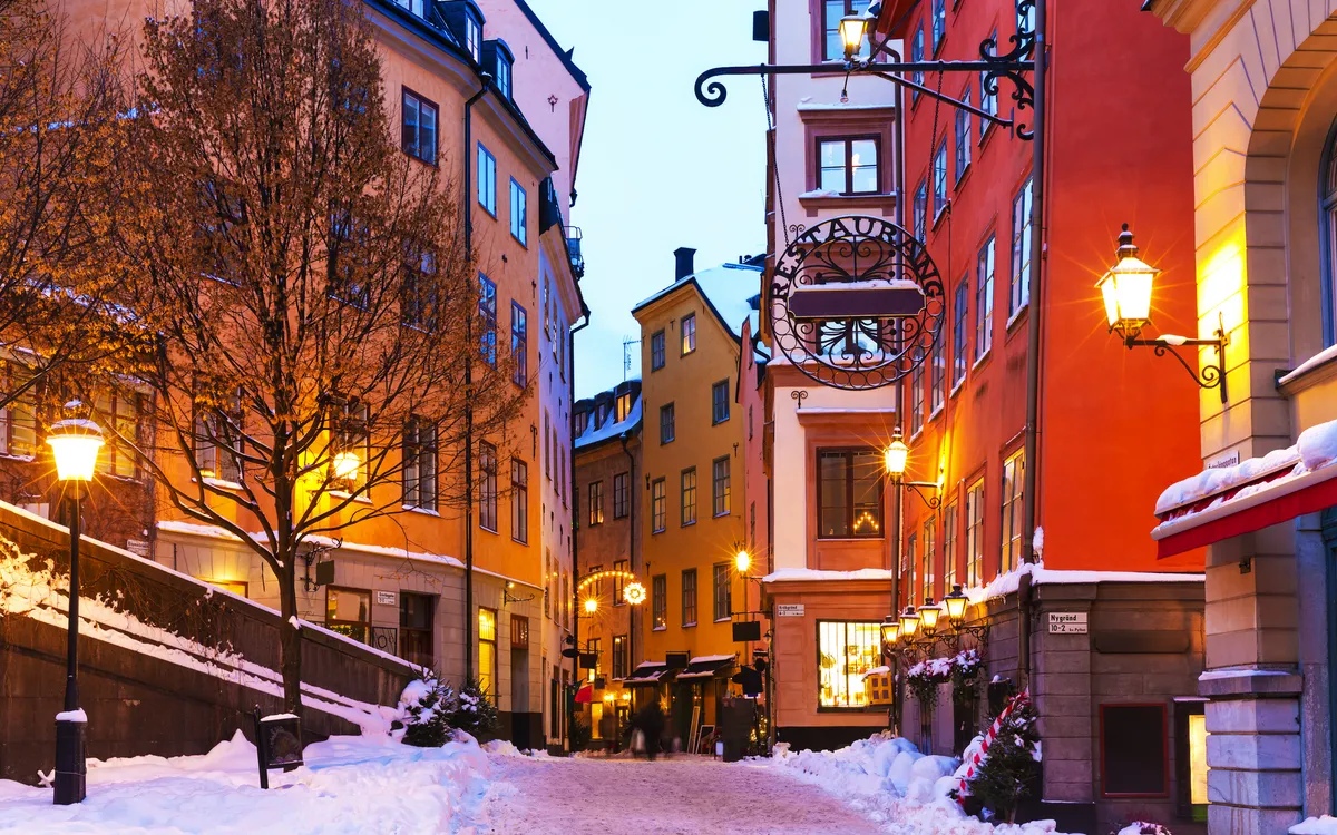 Winterliche Altstadtstraße mit bunten Gebäuden und Laternen.