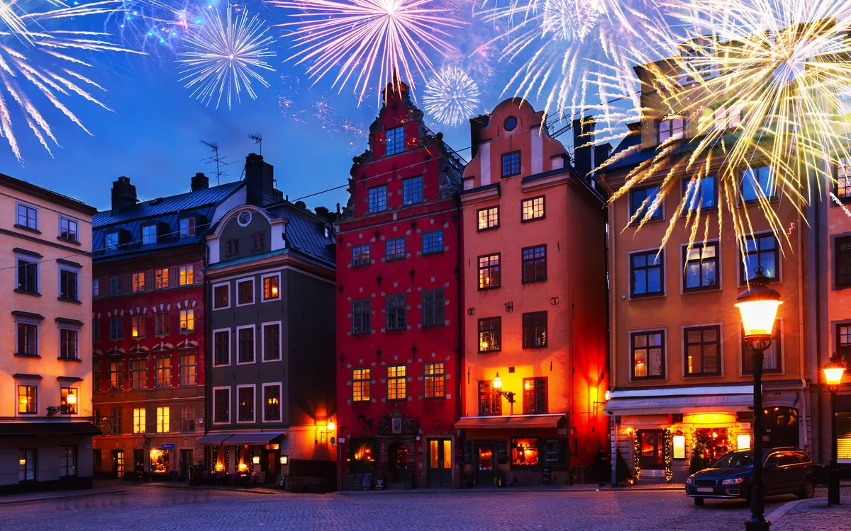 Altstadtgebäude bei Nacht, erleuchtet von Feuerwerk.