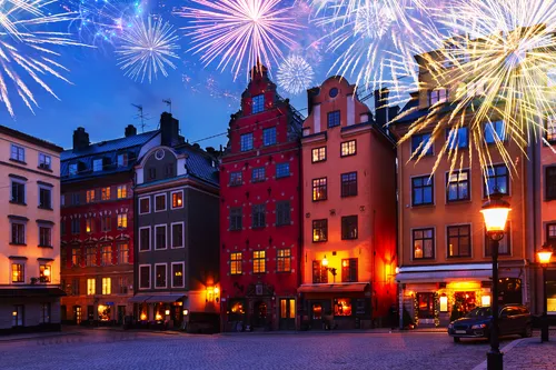 Altstadtgebäude bei Nacht, erleuchtet von Feuerwerk.