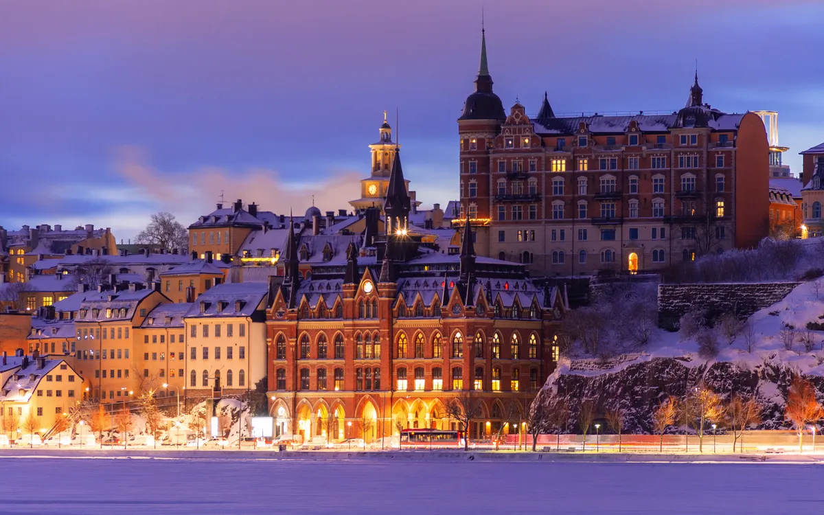 Winterliche Stadtansicht mit beleuchteten historischen Gebäuden bei Dämmerung.