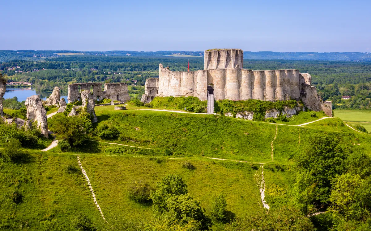 Mittelalterliche Burgruine auf Hügel mit grüner Landschaft.