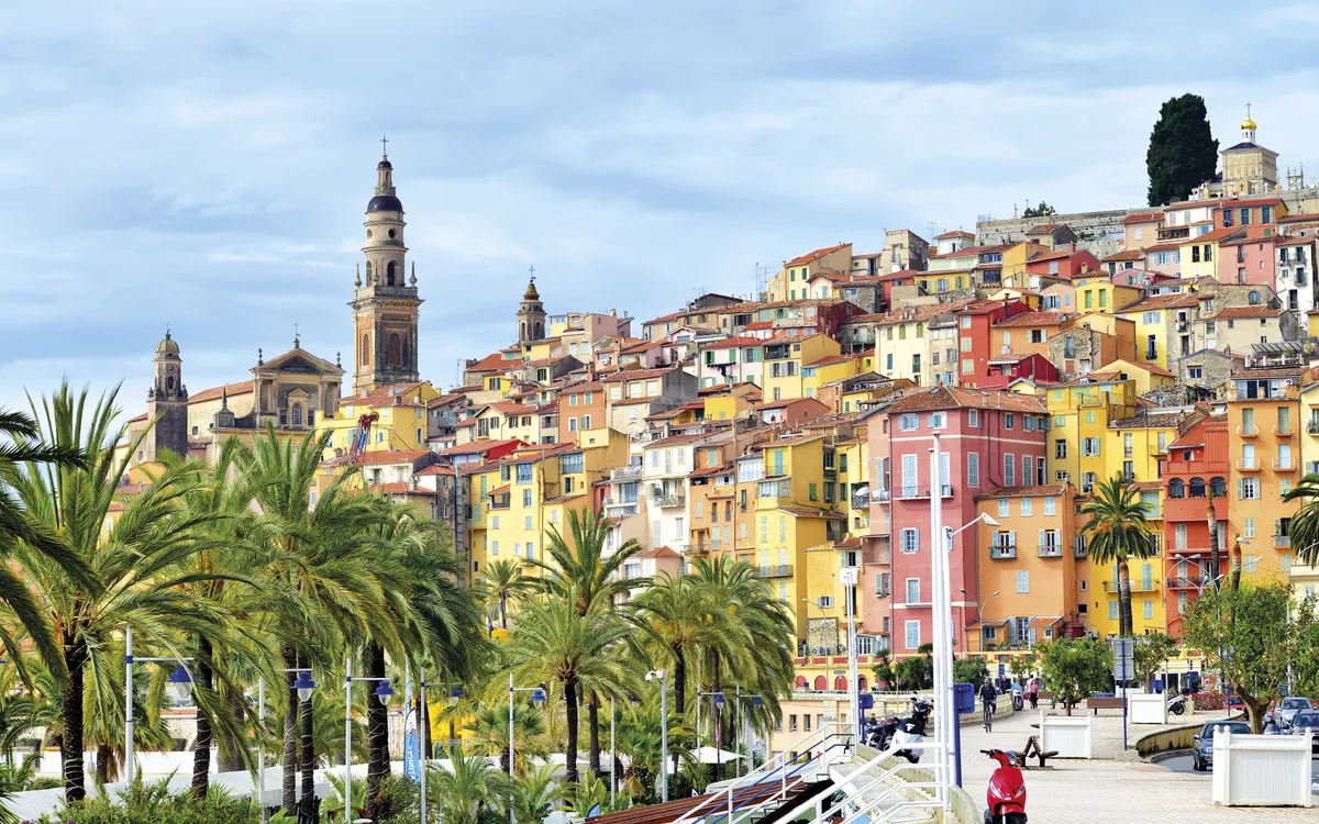Promenade von Menton mit Palmen und bunten Häusern im Hintergru