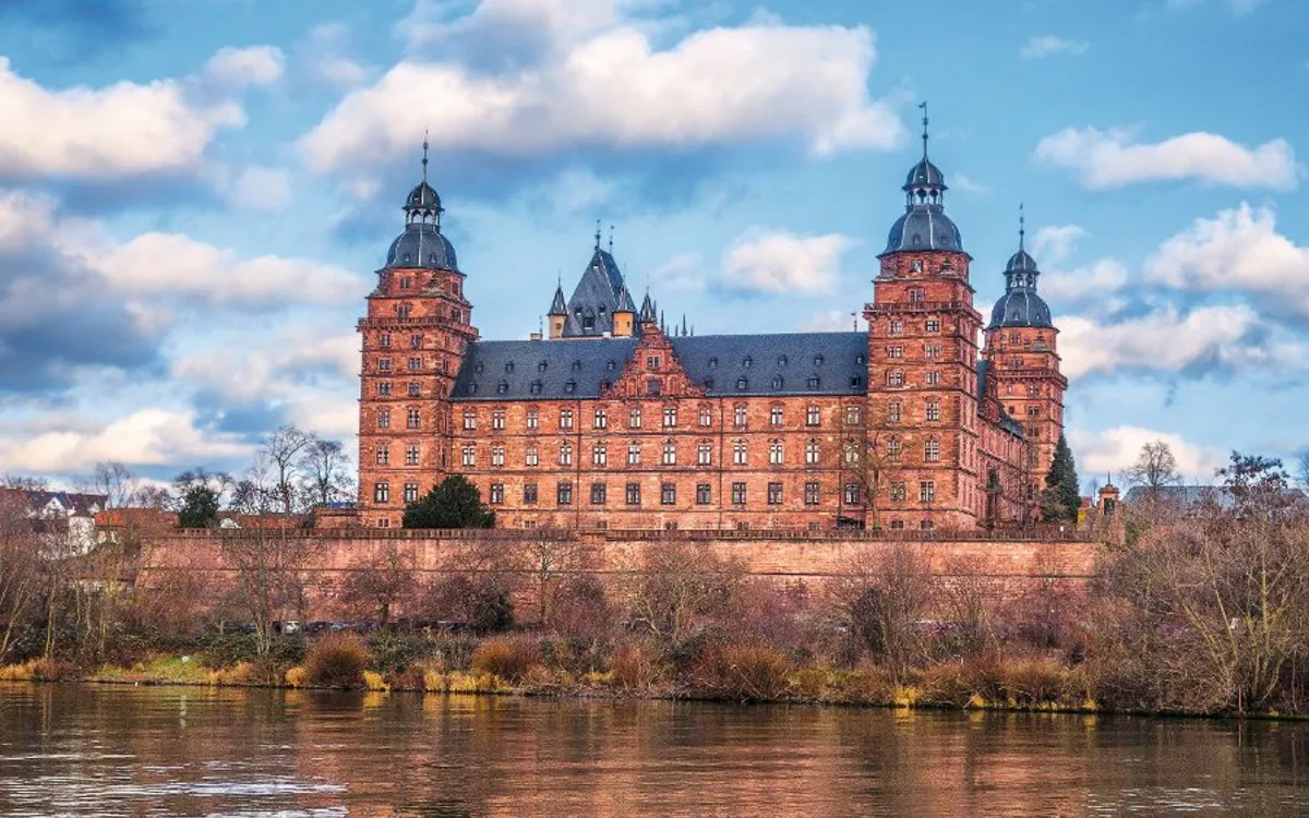 Schloss Johannisburg am Main mit blauem Himmel und Wolken im Hintergrund.