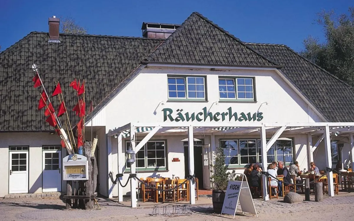 Außenansicht eines Fischrestaurants mit Terrasse und Gästen, Fischland-Darß-Zingst.