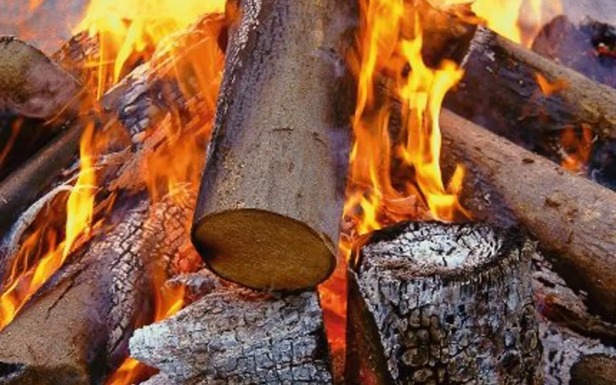 Brennendes Lagerfeuer mit Holzscheiten im Freien.