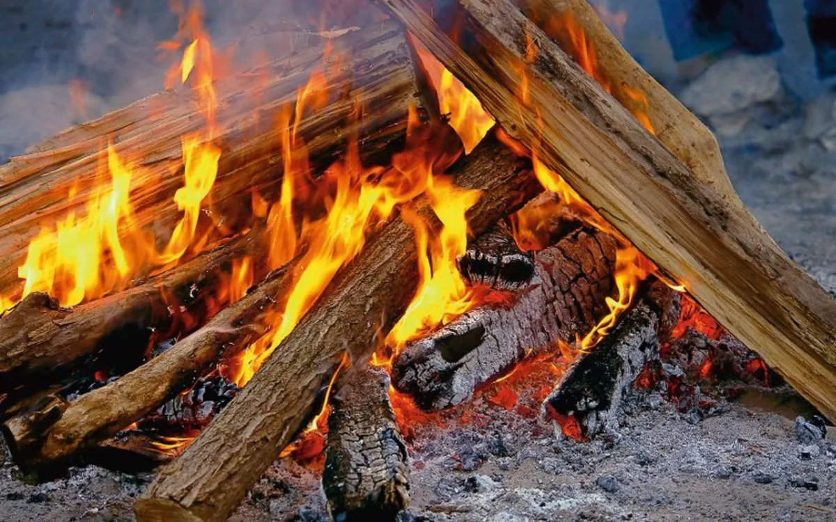 Ein brennendes Lagerfeuer aus Holzscheiten in der Mittsommernacht.