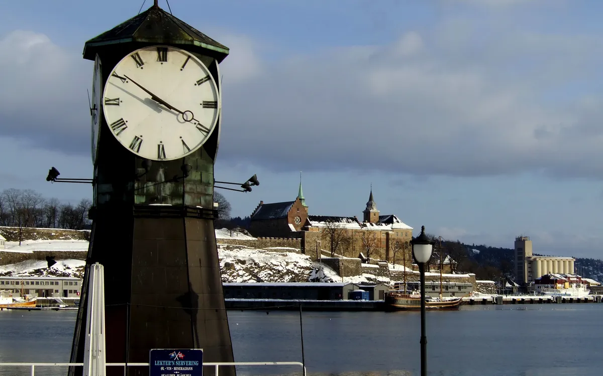 Aker Brygge in Oslo im Winter mit schneebedecktem Boden und Hafenansicht.