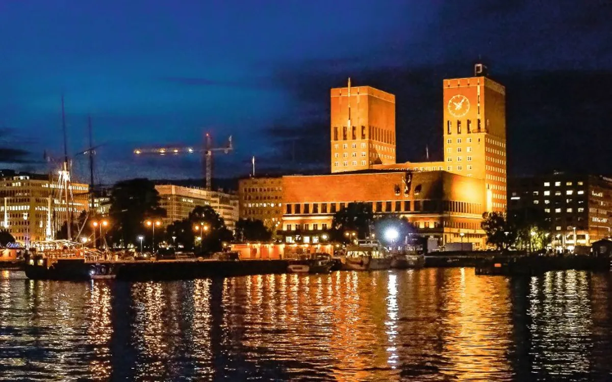 Osloer Rathaus bei Nacht, beleuchtet, an der Uferpromenade, Norwegen.