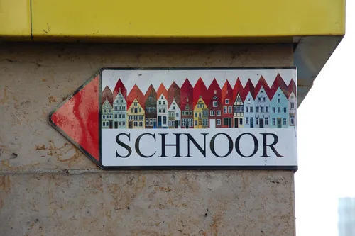 Straßenschild mit bunten Häusern und dem Wort Schnoor.