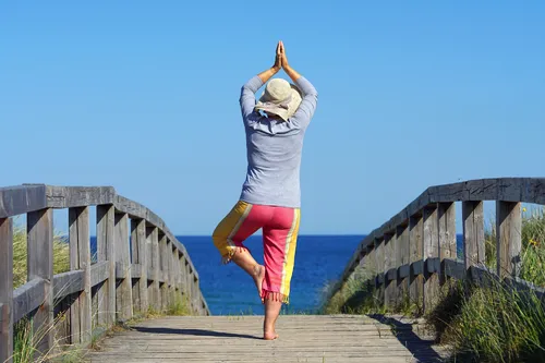 Frau in Yoga Pose am Strandübergang