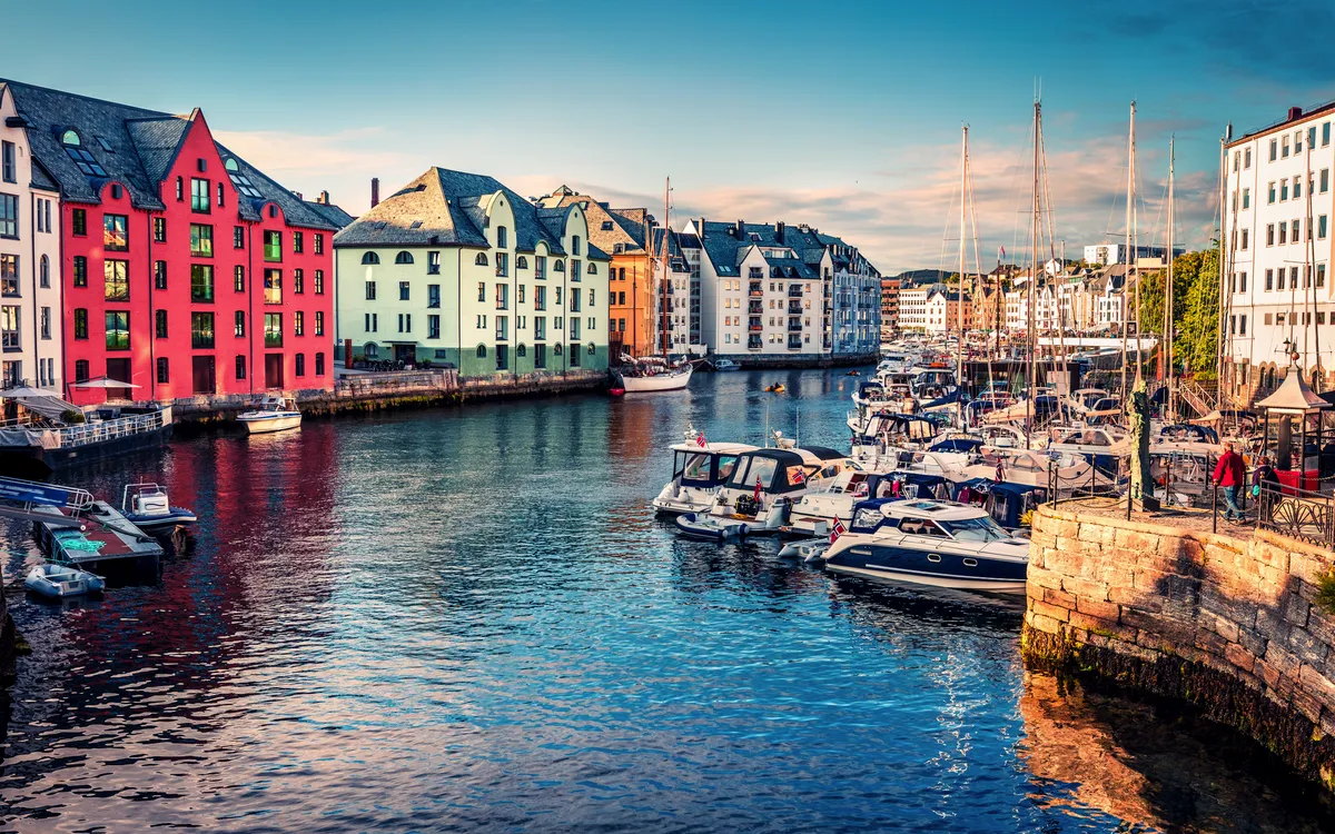Bunte Gebäude und Boote im Hafen von Ålesund, Norwegen.