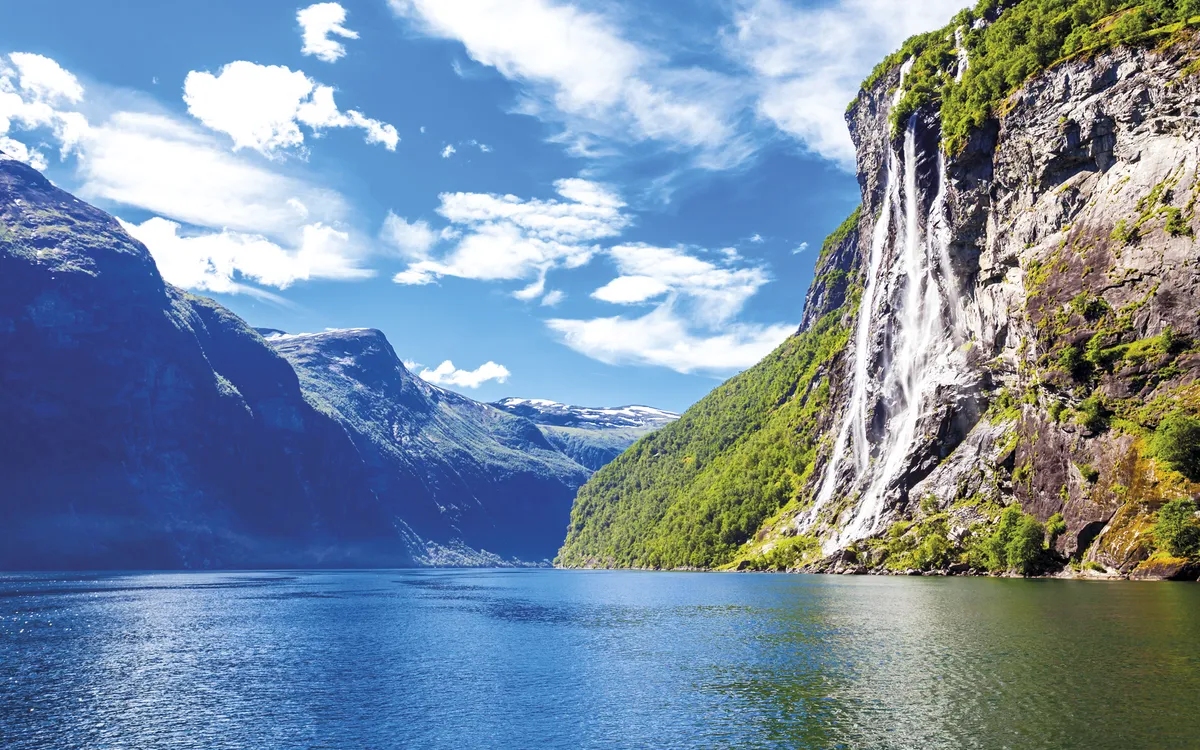 Wasserfall im Geirangerfjord, Norwegen, umgeben von Bergen und klarem Wasser.