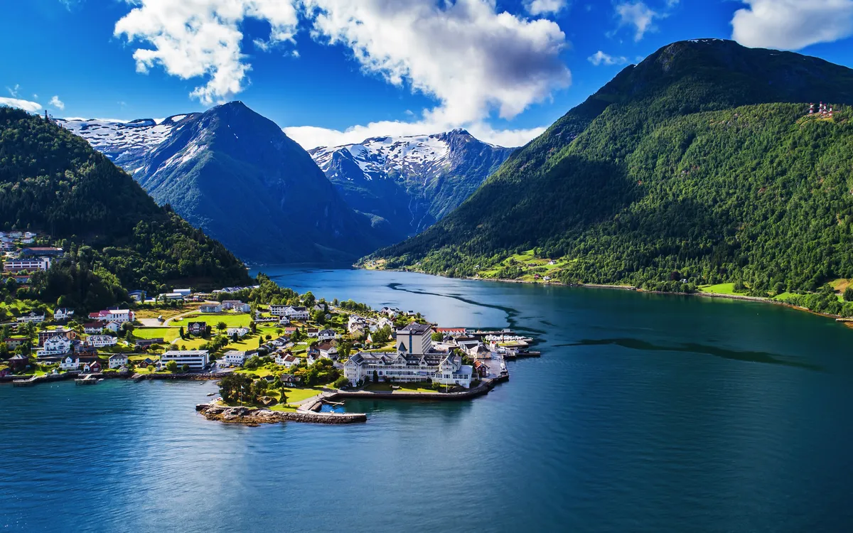 Blick auf Balestrand am Sognefjord mit umliegenden Bergen und Häusern.