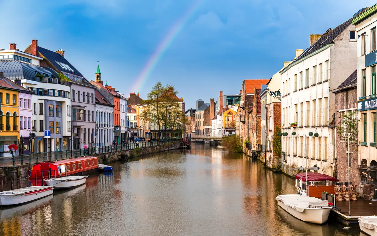Altstadt von Gent mit Fluss und Regenbogen im Hintergrund