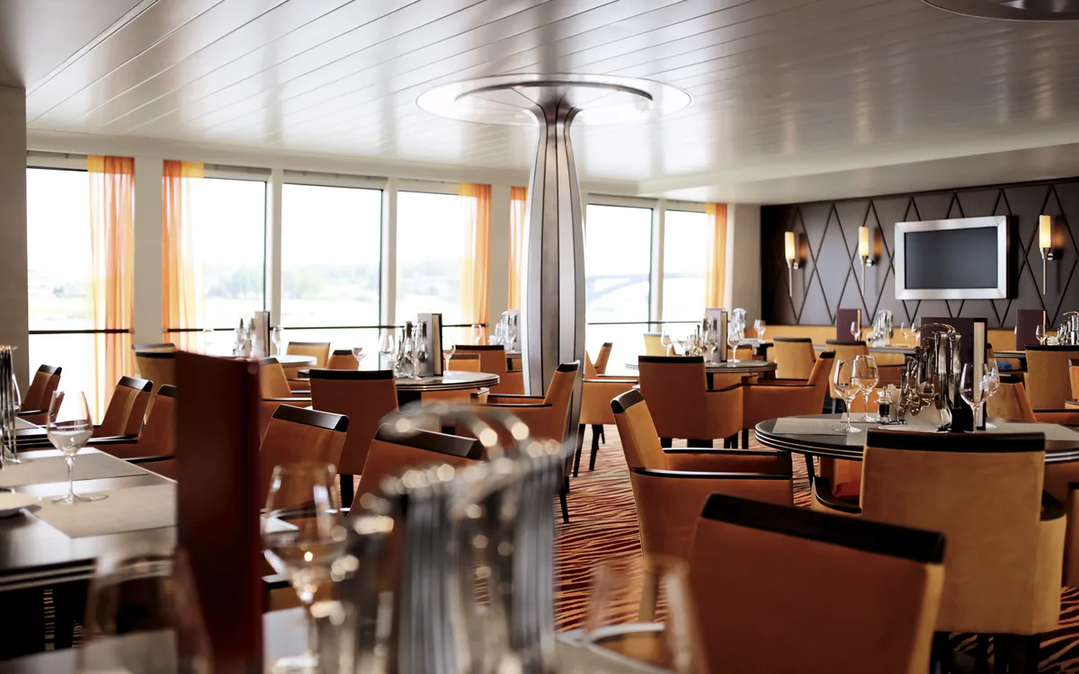 Modernes Restaurant mit gedeckten Tischen im A-ROSA AQUA Schiff.