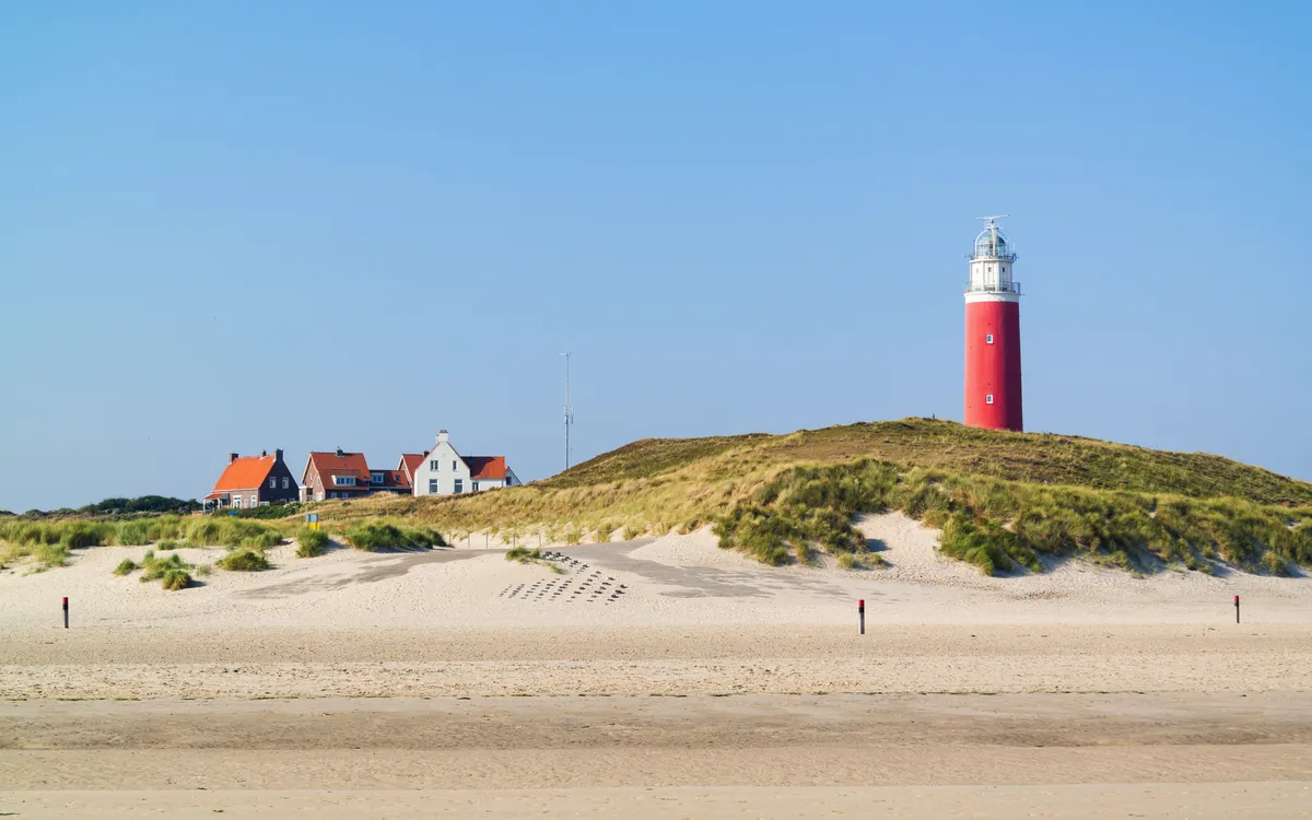 Strand mit Leuchtturm De Cocksdorp auf Texel, Niederlande.